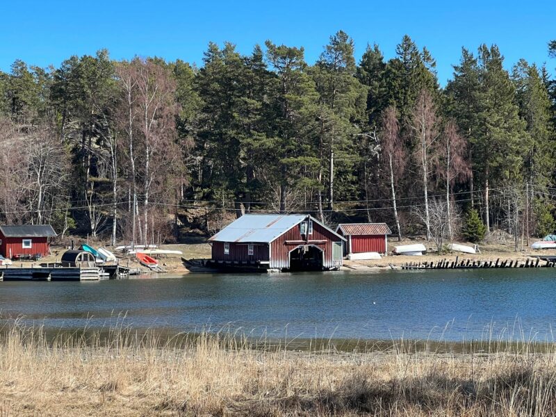 Red boat moored at wooden pier on Arholma Island, Stockholm Archipelago Trail