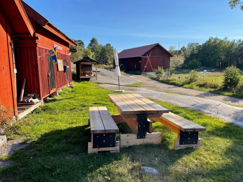 Red wooden building with picnic table at Ingmarsö Island, Stockholm Archipelago Trail