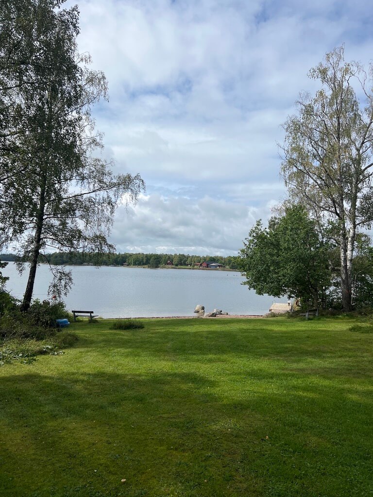 Green lawn with trees overlooking the sea in Furusund, Stockholm Archipelago Trail